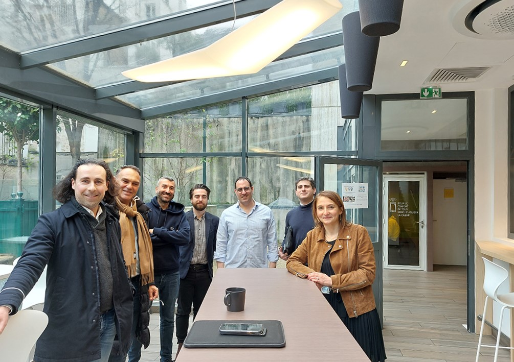 7 personnes souriantes autour d'une table au Neuilly Lab